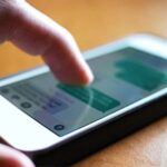 Person scrolls through generic messages on generic smartphone