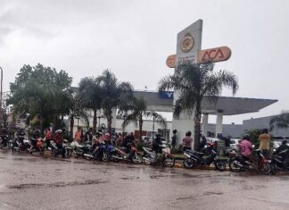 Largas colas y motos bajo la lluvia por combustible